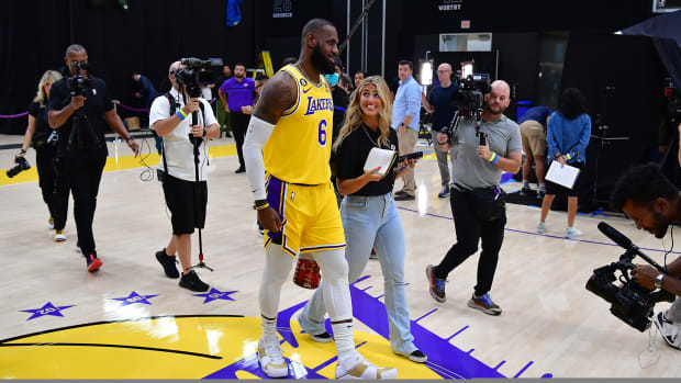 LeBron James walks and talks with a media member.